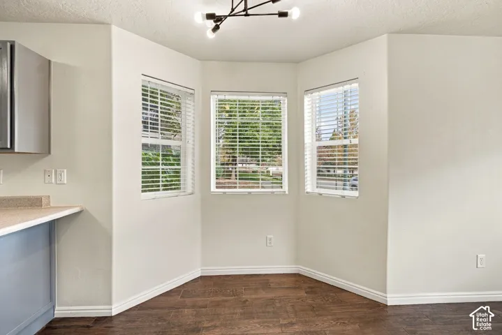 Bay window featuring three paneled windows, wood-finish flooring, and a modern multi-arm geometric light fixture