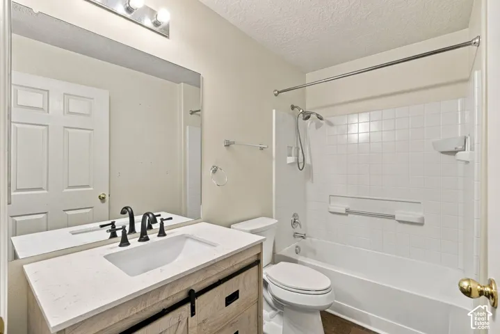 Bathroom featuring a wood-finish vanity with a stone-composite countertop, undermount sink, matte black widespread faucet, and a large frameless mirror