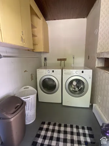 Utility area featuring wall-mounted cabinetry, a wood-plank ceiling, and hookups for laundry appliances