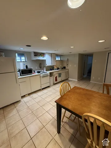 Kitchen featuring tile flooring, white cabinetry, integrated range hood, and recessed lighting