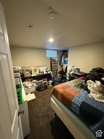 Interior room featuring dark carpeting, recessed ceiling lighting, a recessed closet area, and a single window with blinds