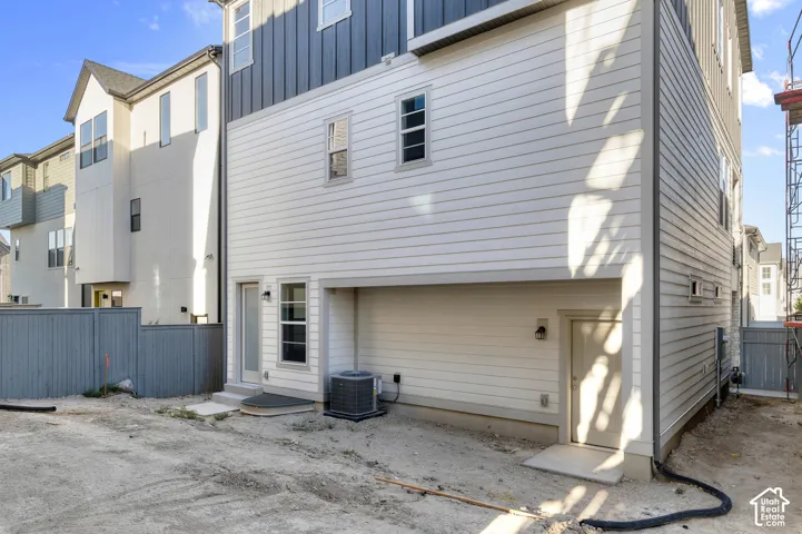 Exterior featuring mixed horizontal lap and vertical panel siding, multiple rectangular windows, two exterior-access doors, and a concrete foundation