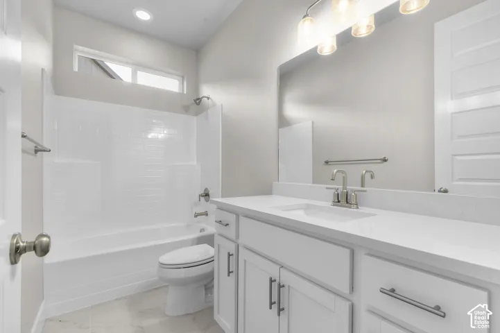 White vanity with composite countertop, rectangular undermount sink, integrated tub and shower combination with subway-tile pattern surround, large wall-mounted mirror, and multi-bulb vanity lighting