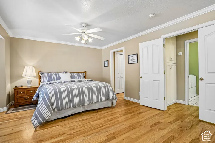 Room with wood-finish flooring, crown molding, ceiling fan with integrated lighting, and white six-panel interior doors
