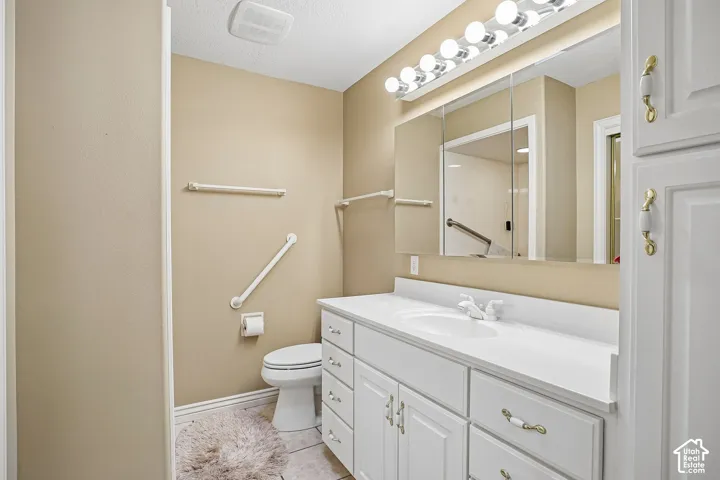 Bathroom featuring a white vanity with integrated basin, multi-drawer storage, mirrored medicine cabinet, and overhead light fixture