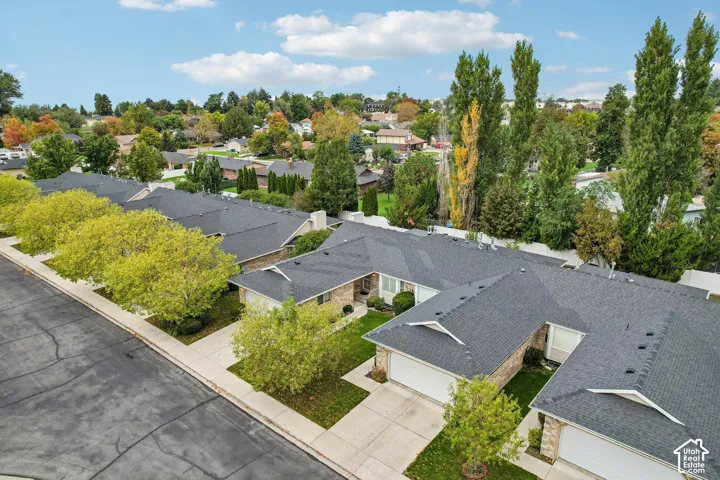 Aerial perspective of residential structures featuring multi-gable roofs, brick exterior accents, and attached garages with concrete driveways