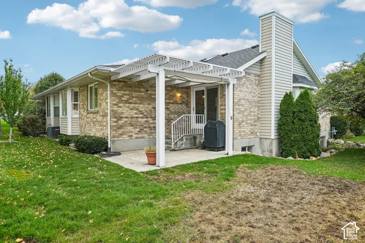 Charming brick and siding residence featuring a covered front porch with white columns, gable roofline with decorative trim, and manicured landscaping including mature evergreen shrubs