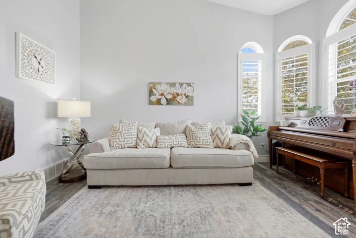 High ceilings, wood-finish flooring, and arched windows with plantation shutters