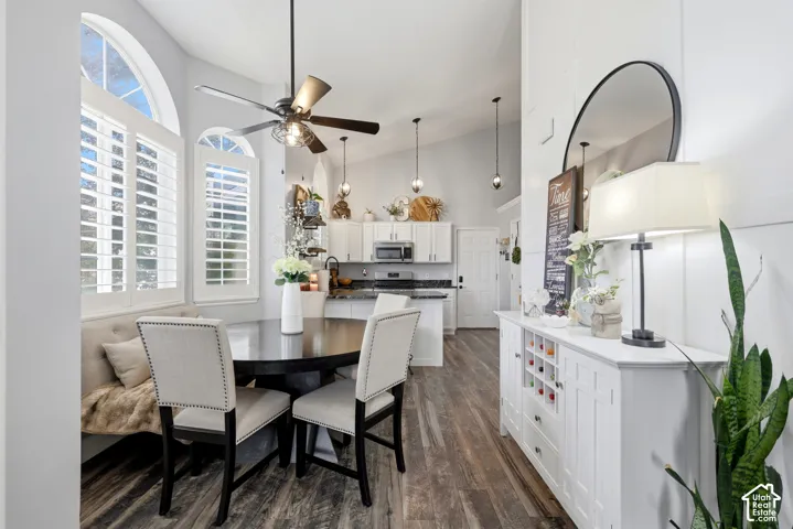 Vaulted ceilings, wood-finish flooring, arched windows with plantation shutters, and pendant lighting