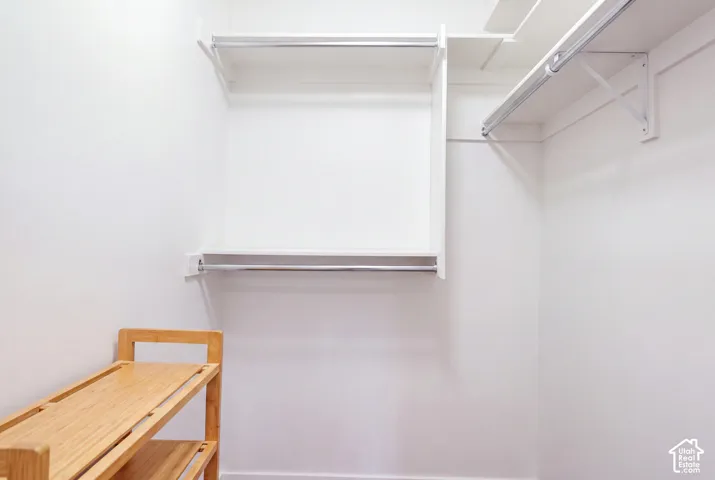 Built-in white storage shelving and chrome-finish garment rods