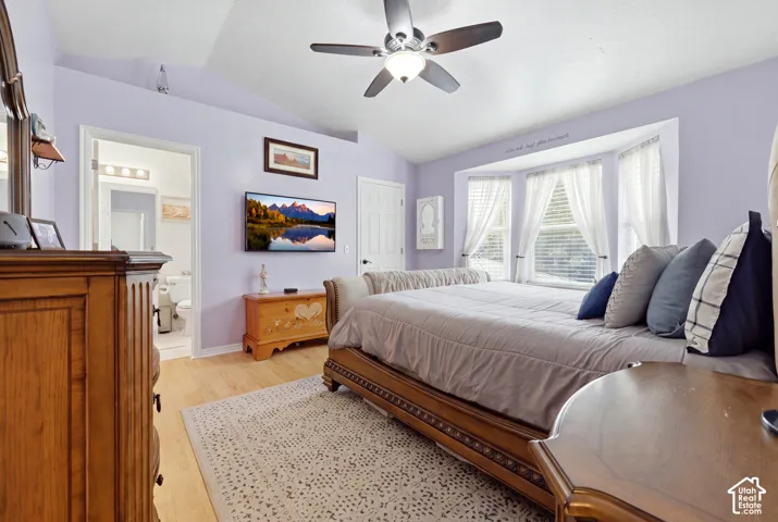 Vaulted ceiling, bay window, wood-finish flooring, and ceiling fan with integrated lighting