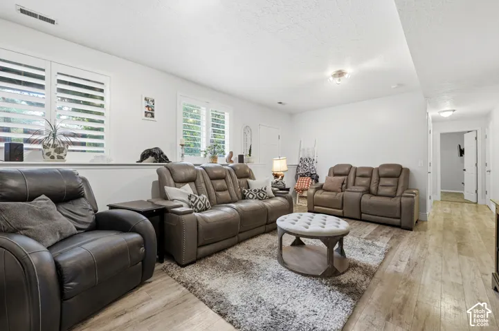 Interior space featuring wood-finish flooring, adjustable plantation shutters, recessed and flush-mount lighting, and multi-panel doors