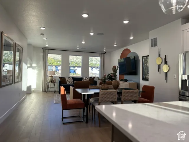Open-concept interior featuring light wood-finish flooring, recessed lighting, and large windows with exterior mountain scenery