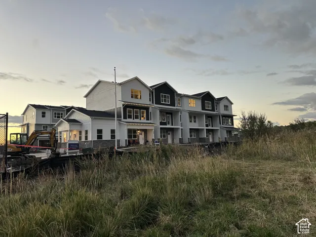 Multi-unit residential exterior featuring mixed-material siding, stone veneer accents, gabled rooflines, and multi-pane windows