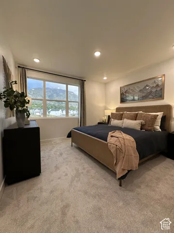 Neutral carpeted flooring, recessed ceiling lighting, and large picture window with mountain backdrop