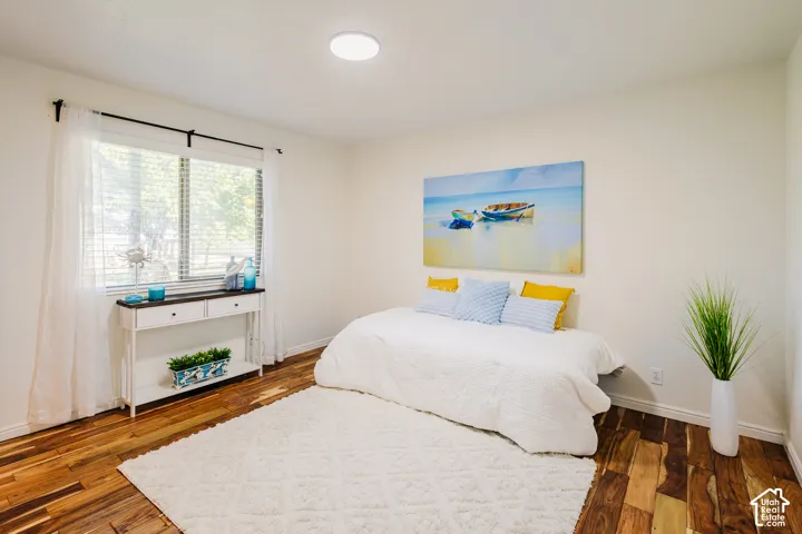 Neutral wall finishes, wood-finish flooring, and natural light provided by a dual-pane window