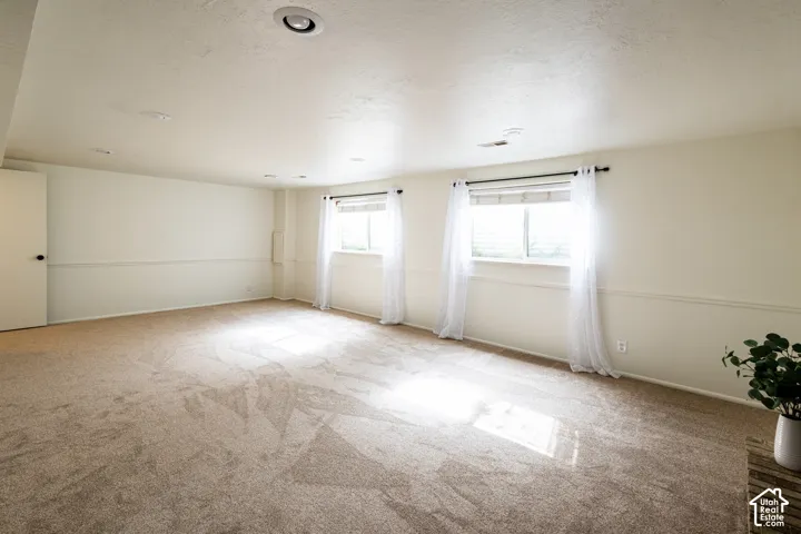 Neutral-toned wall-to-wall carpeting, recessed ceiling lighting, and chair rail molding accents