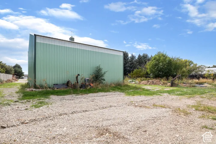 Detached metal-sided structure featuring a metal roof, cupola, and gravel exterior grounds