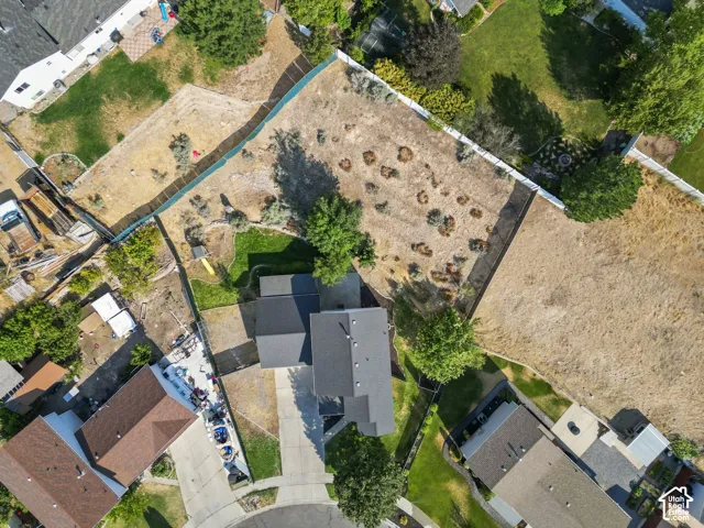 Expansive corner lot featuring a multi-tiered backyard, mature trees, and perimeter fencing
