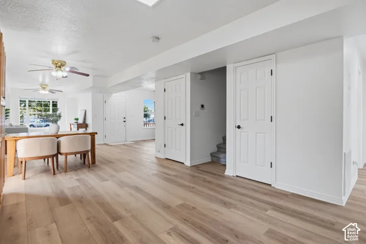 Wood-finish flooring, dual ceiling fans, multi-panel interior doors, and crisp white wall finishes