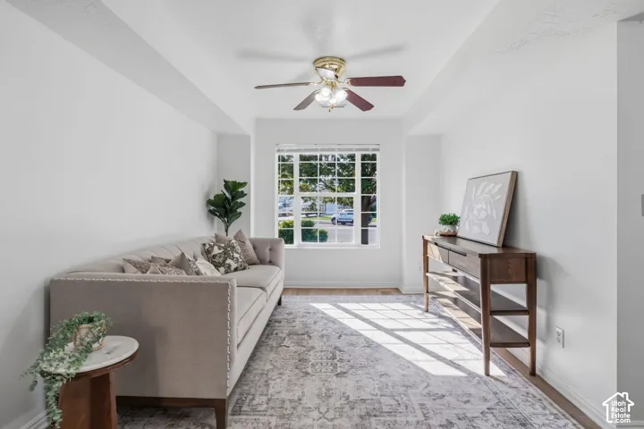 Tray ceiling, multi-pane window, and a central ceiling fan with integrated lighting