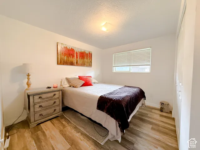Wood-finish flooring, horizontal window blinds, and dual-panel closet doors