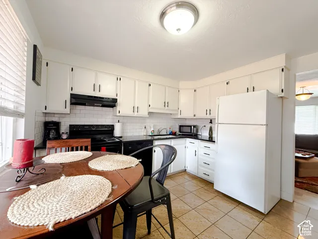 Kitchen featuring white cabinetry, subway tile backsplash, dark countertops, tile flooring, and a flush-mount ceiling light