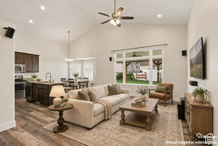 Vaulted ceilings, wood-finish flooring, recessed lighting, ceiling fan, and large-format multi-pane windows