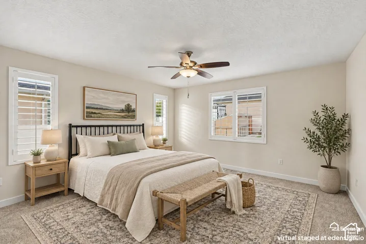 Room featuring neutral wall paint, carpeted flooring, three windows with white plantation shutters, and a central ceiling fan with integrated lighting