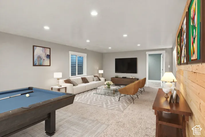 Spacious interior featuring recessed lighting, horizontal wood-plank accent wall, carpeted flooring, and window with casing