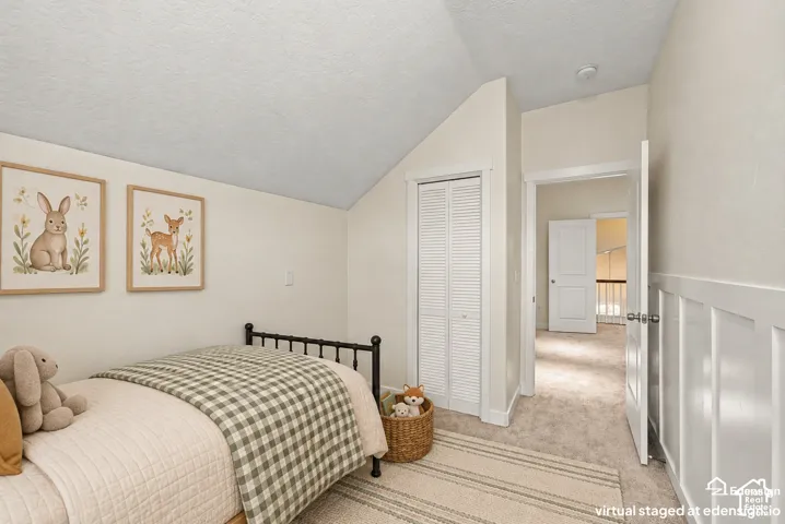 Sloped ceiling, white louvered-door closet, and white wainscoting