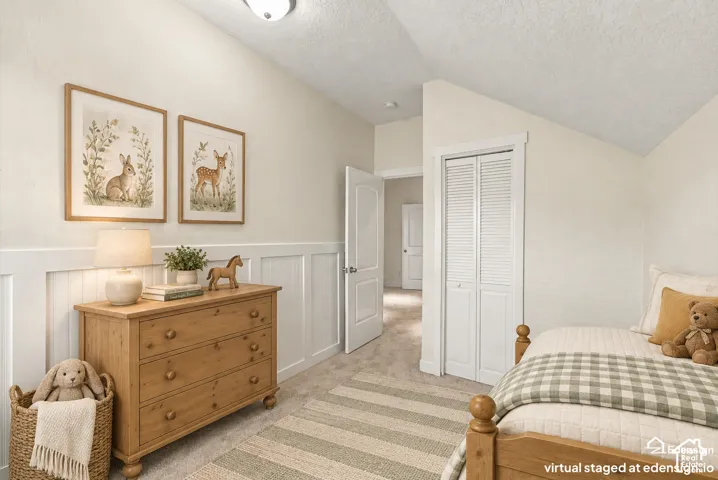 Vaulted ceiling, white wainscoting, and closet with louvered doors