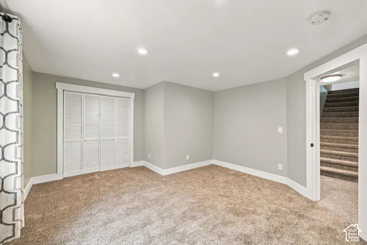 Neutral-toned interior featuring wall-to-wall carpeting, recessed ceiling lighting, and a bi-fold closet door with white trim