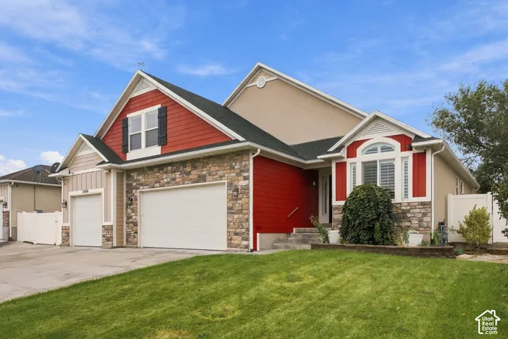 Multi-level exterior featuring a combination of horizontal siding, stone veneer accents, multi-gabled roofline, three-car garage, and concrete driveway