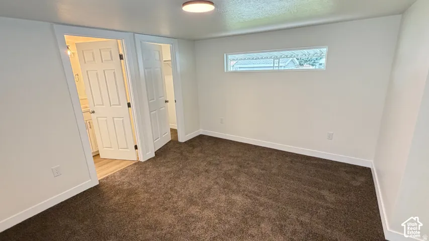 Room featuring wall-to-wall carpeting, dual interior doors, and a horizontal rectangular window