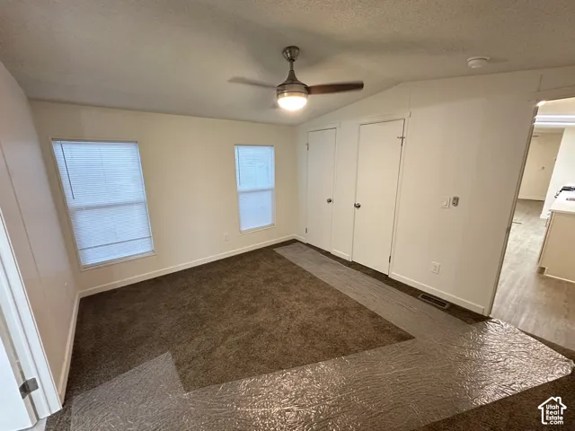 Room featuring wall-to-wall carpeting, dual windows with integrated blinds, a ceiling fan with light fixture, and two sets of interior doors