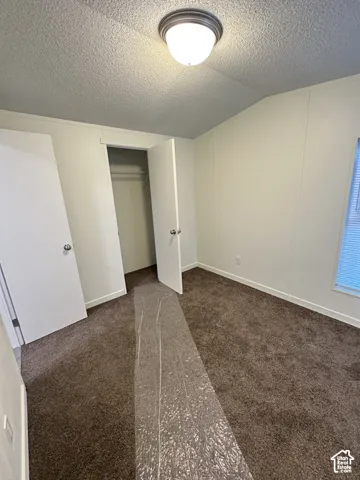 Neutral wall-finish, wall-to-wall carpeting, and a built-in closet with double-hinged doors, illuminated by a ceiling-mounted dome fixture