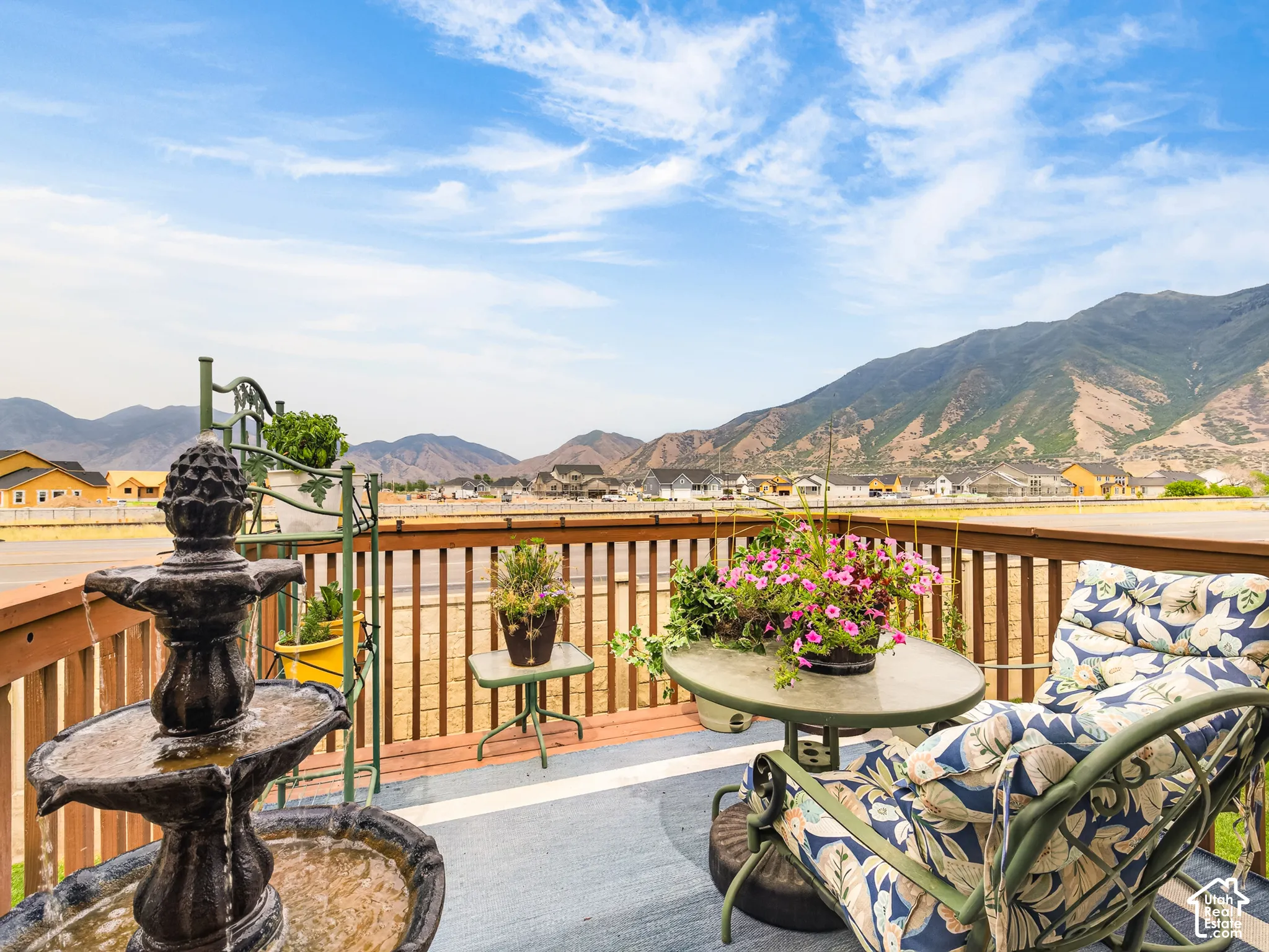 Elevated wooden deck featuring a horizontal slat railing and expansive mountain backdrop