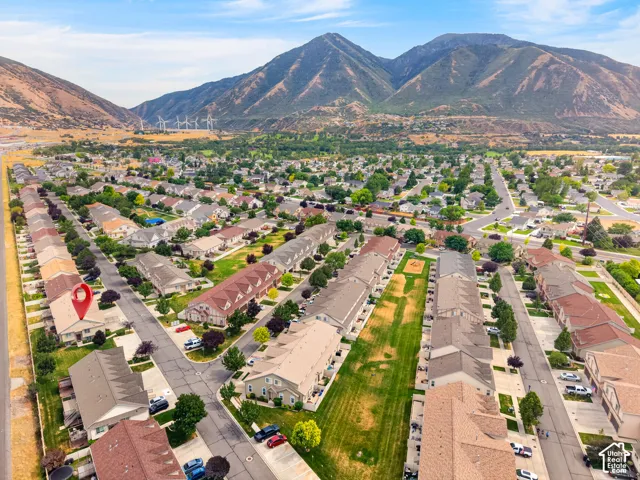 Aerial perspective of residential community featuring mountain backdrops and expansive green spaces