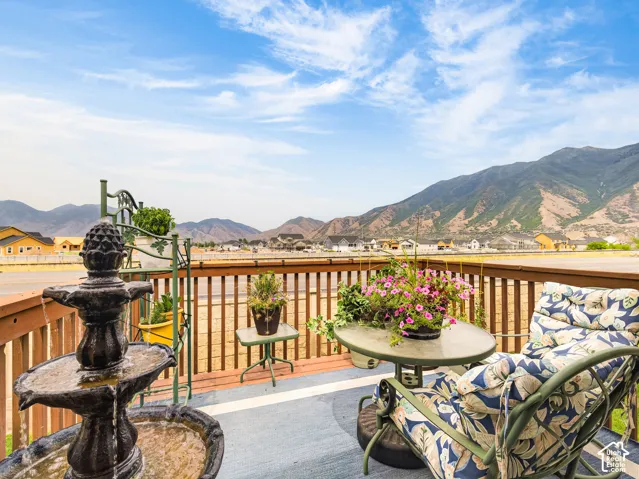 Elevated wooden deck featuring a horizontal slat railing and expansive mountain backdrop