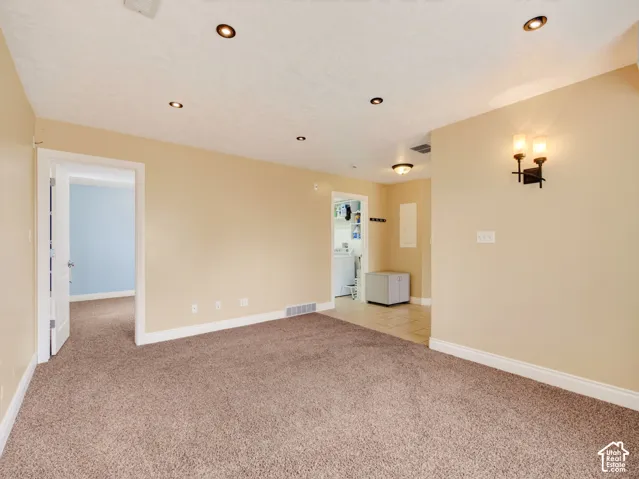 Interior space featuring recessed lighting, wall-mounted sconce fixtures, carpeted flooring, and tiled entryway flooring