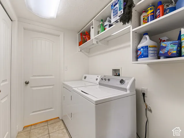 Laundry space featuring ceramic tile flooring, built-in white shelving, and a paneled interior door