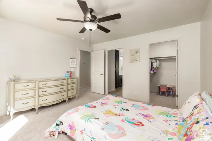 Bedroom featuring neutral wall paint, carpeting, a ceiling fan with integrated lighting, and a reach-in closet