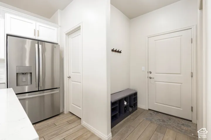 Entry area featuring wood-finish tile flooring, recessed wall niche, and six-panel interior doors
