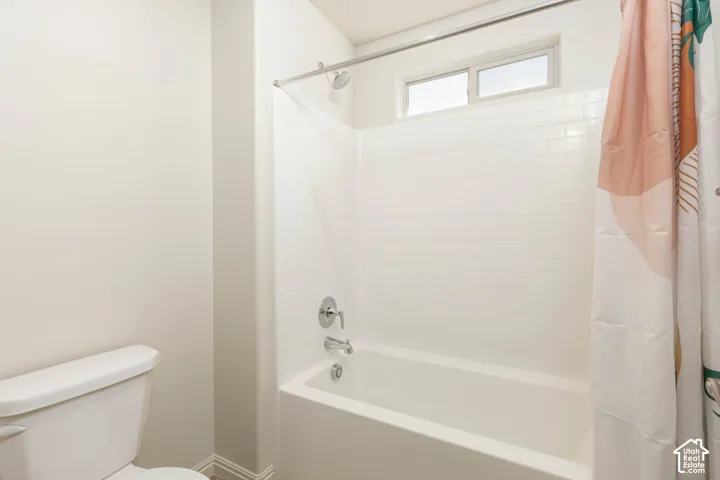 Full bathtub with white subway tile surround, polished chrome fixtures, and a high-positioned horizontal window