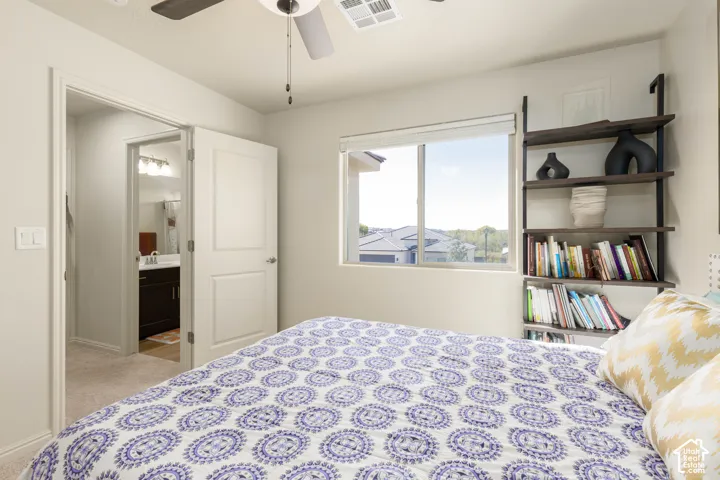 Neutral wall paint, ceiling fan with integrated lighting, slider window with horizontal blinds, and carpeted flooring