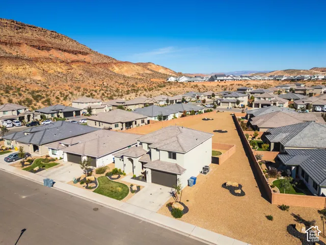 Two-story residence featuring a tile roof, stucco exterior, attached garage, and mountain backdrop