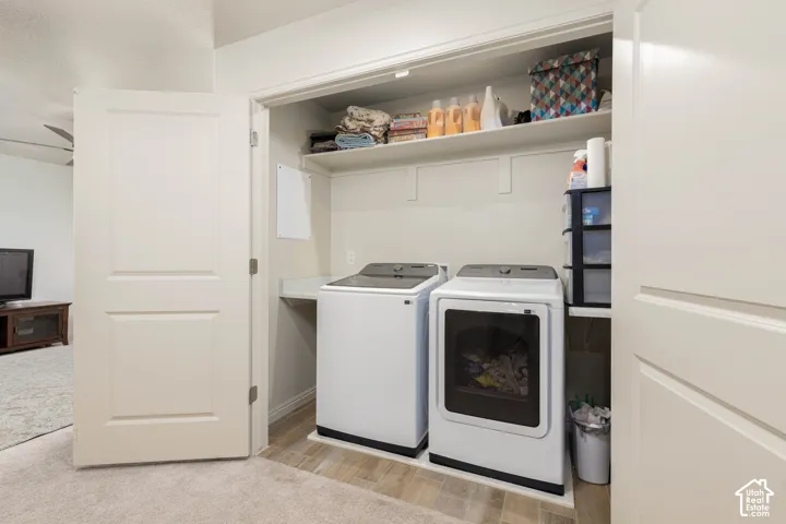 Laundry closet featuring wood-finish flooring, a built-in folding counter, and overhead shelving