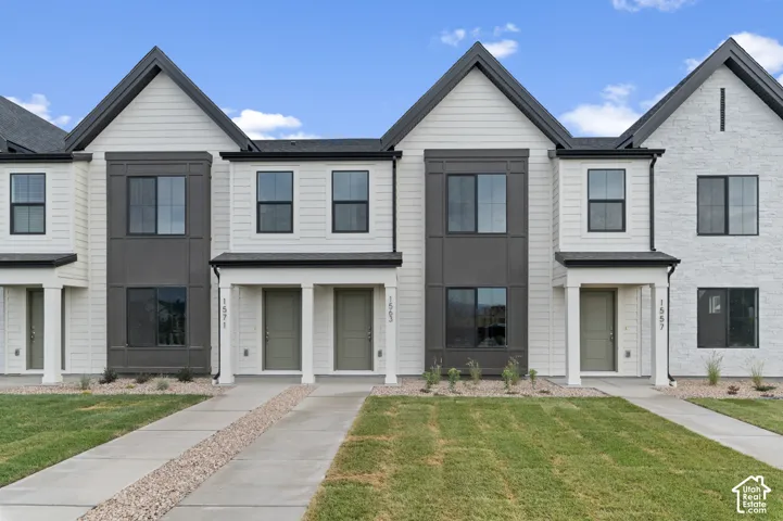Multi-unit exterior featuring board-and-batten and horizontal siding, stone veneer accents, pitched rooflines, and covered entries