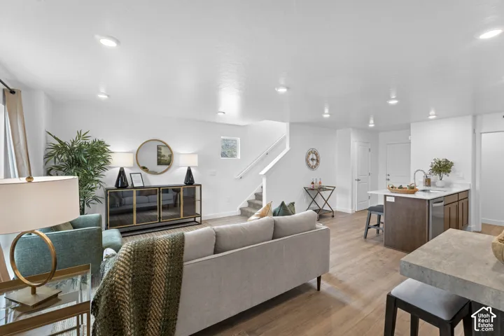 Open floor plan featuring wood-finish flooring, recessed lighting, and a kitchen island with stone countertop